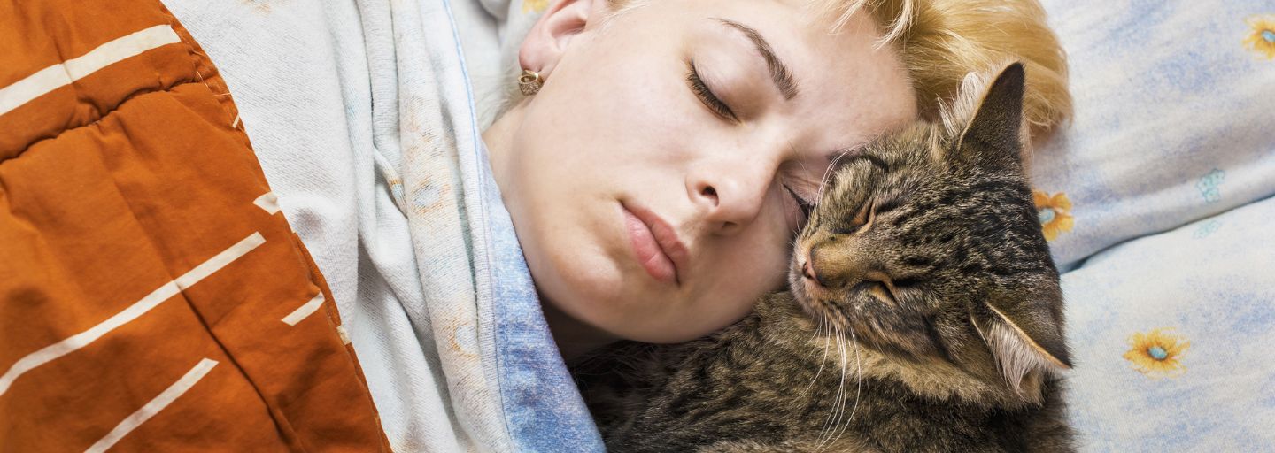 Owner and cat cuddling together